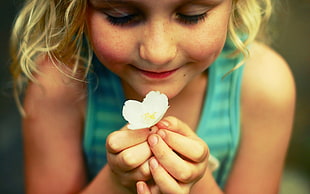 selective focus photography of girl holding white flower